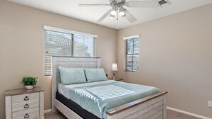A bedroom with a bed, a nightstand, a lamp, a ceiling fan, and windows with blinds. - Sleeps 14 Pool Spa Fire Pit Billiards EV Plug (Mesa)
