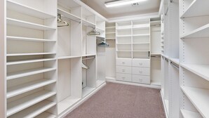 A walk-in closet with open shelving, hanging space, and drawers. - Sleeps 14 Pool Spa Fire Pit Billiards EV Plug (Mesa)