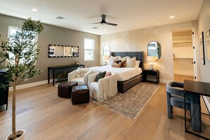 A bedroom with a bed, bedside tables, a desk, a chair, a mirror, and a plant. - Old Town Estate Pool Theater Game Room (Scottsdale)