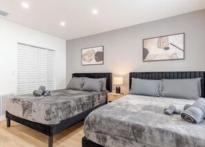 Ein Schlafzimmer mit zwei Betten, einem Nachttisch mit Lampe und einem Bild an der Wand.