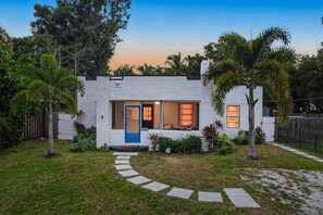 A single-story house with a white exterior, a blue door, and a small front porch. - Bradenton Bliss Heated Pool Hot Tub Games (Bradenton)
