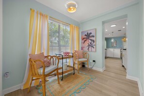 A dining area with a table, chairs, and a window with curtains. - Bradenton Bliss Heated Pool Hot Tub Games (Bradenton)