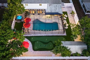 A residential backyard with a swimming pool, a hot tub, and a small putting green. - Epic Backyard - Pool - Hot Tub - Outdoor Theatre (Bradenton)