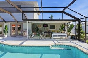 A covered outdoor area with a pool, seating, and a grill. - Epic Backyard - Pool - Hot Tub - Outdoor Theatre (Bradenton)