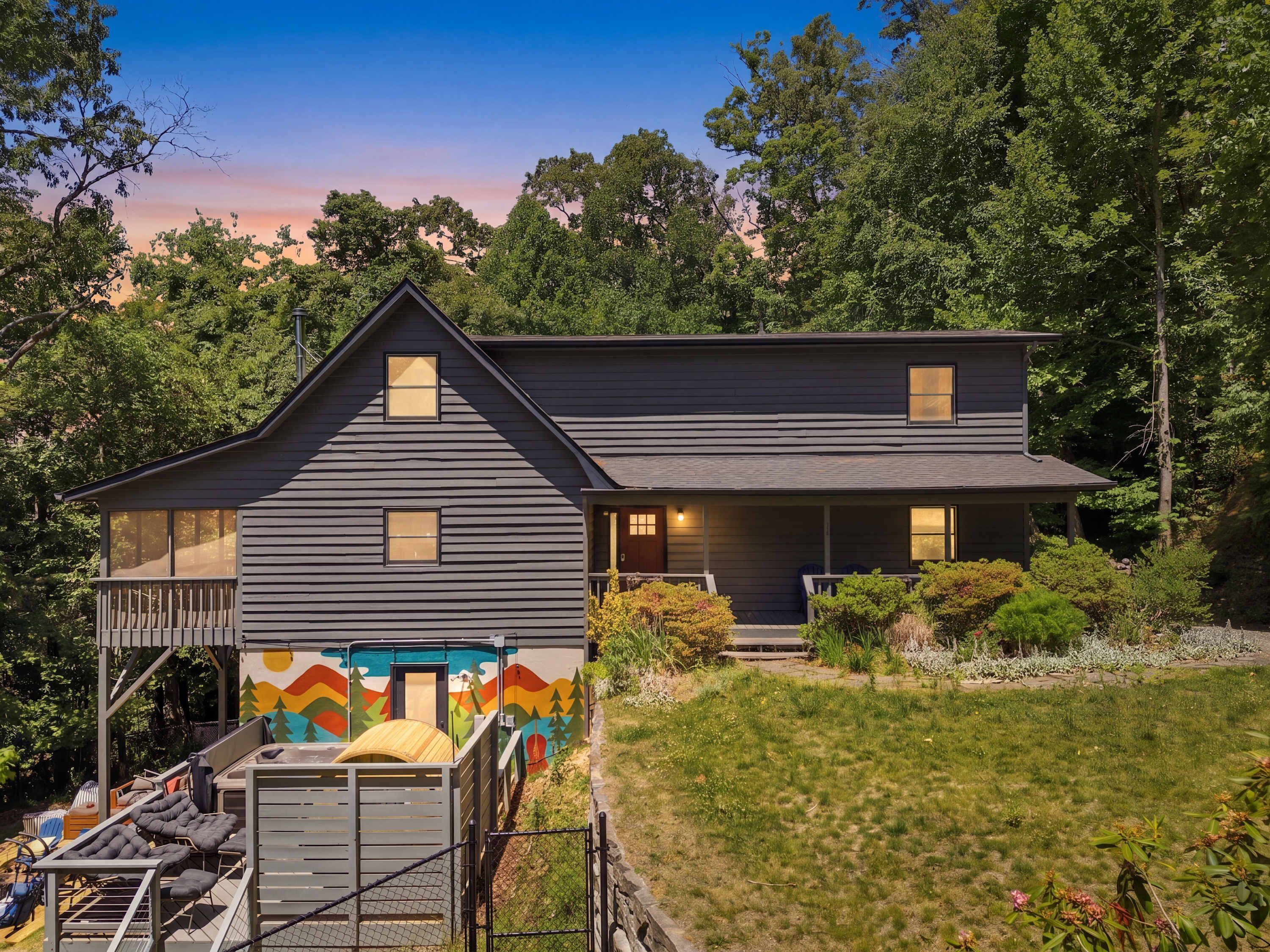 A two-story house with a balcony and a covered outdoor seating area.
