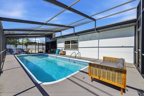 Ein überdachter Pool mit Liegestühlen und einem Fenster.