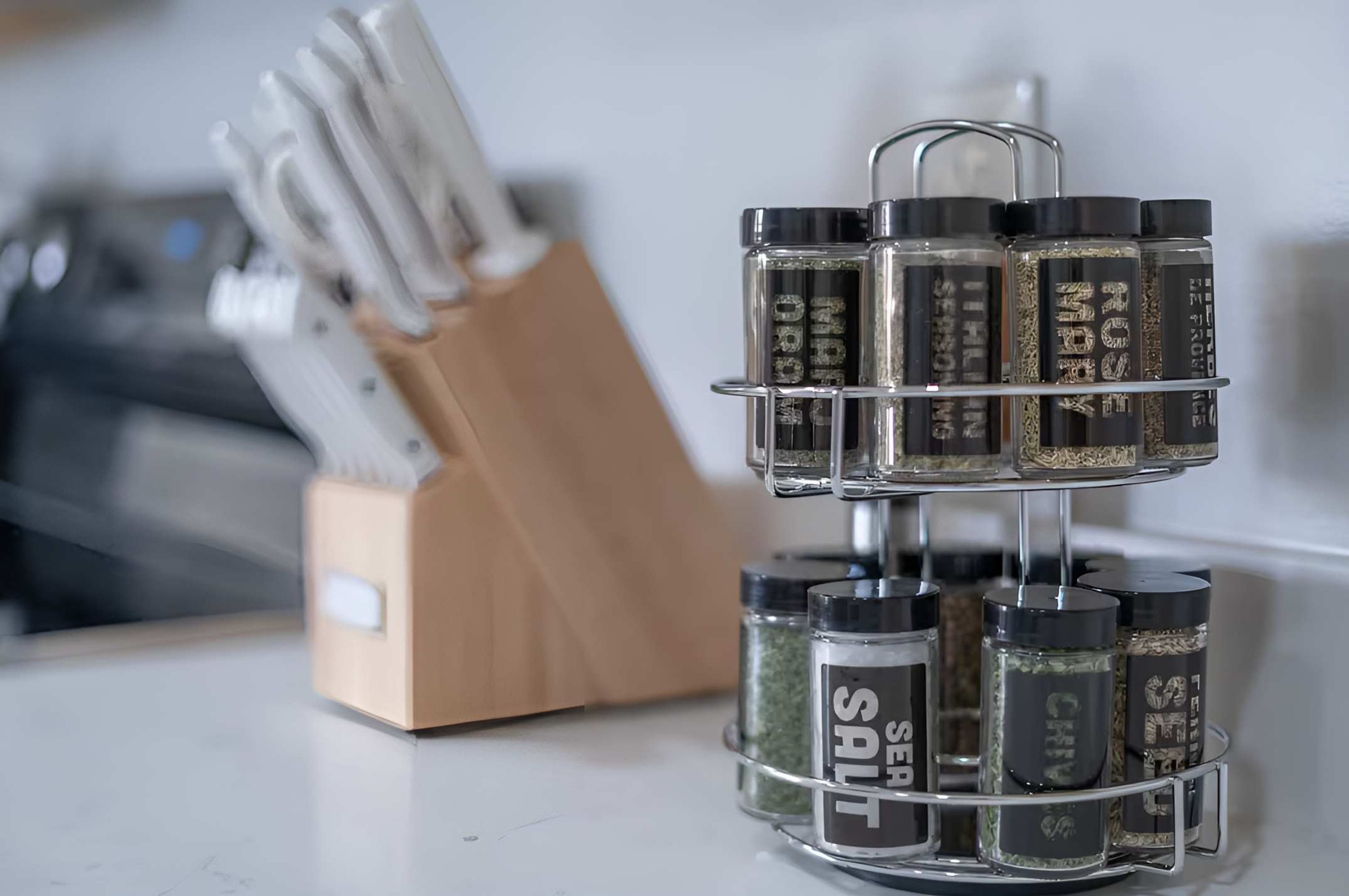 A spice rack with multiple containers, a knife holder, and a kitchen counter.