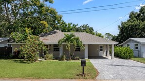 A residential house with a front yard, a driveway, and a mailbox. - Sleeps 6 Private Pool Fire Pit Game House (Sarasota)