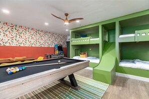 A room with a pool table, green bunk beds, and a ceiling fan. - The Texan Heated Pool Basketball Slide (San Antonio)