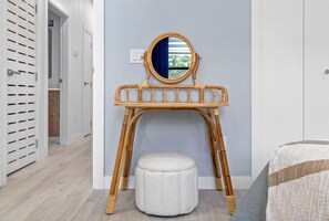 A room with a wooden vanity table, a round mirror, and a white ottoman. - Close to DT Tampa Newly Designed Town Home (Tampa)