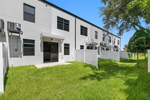 Un bâtiment moderne à la façade plate, doté de grandes fenêtres et d’un petit porche à l’avant.