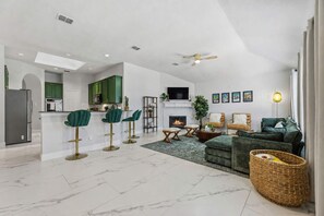 A modern living space with a kitchen, dining area, and seating area. - 4 Themed Rooms 11 Min to Universal Kids (Frisco)
