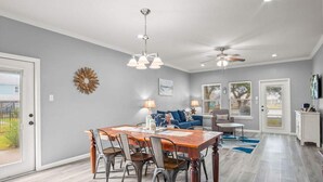 Uma área de refeições com uma mesa e cadeiras de madeira, um ventilador de teto e um candelabro.