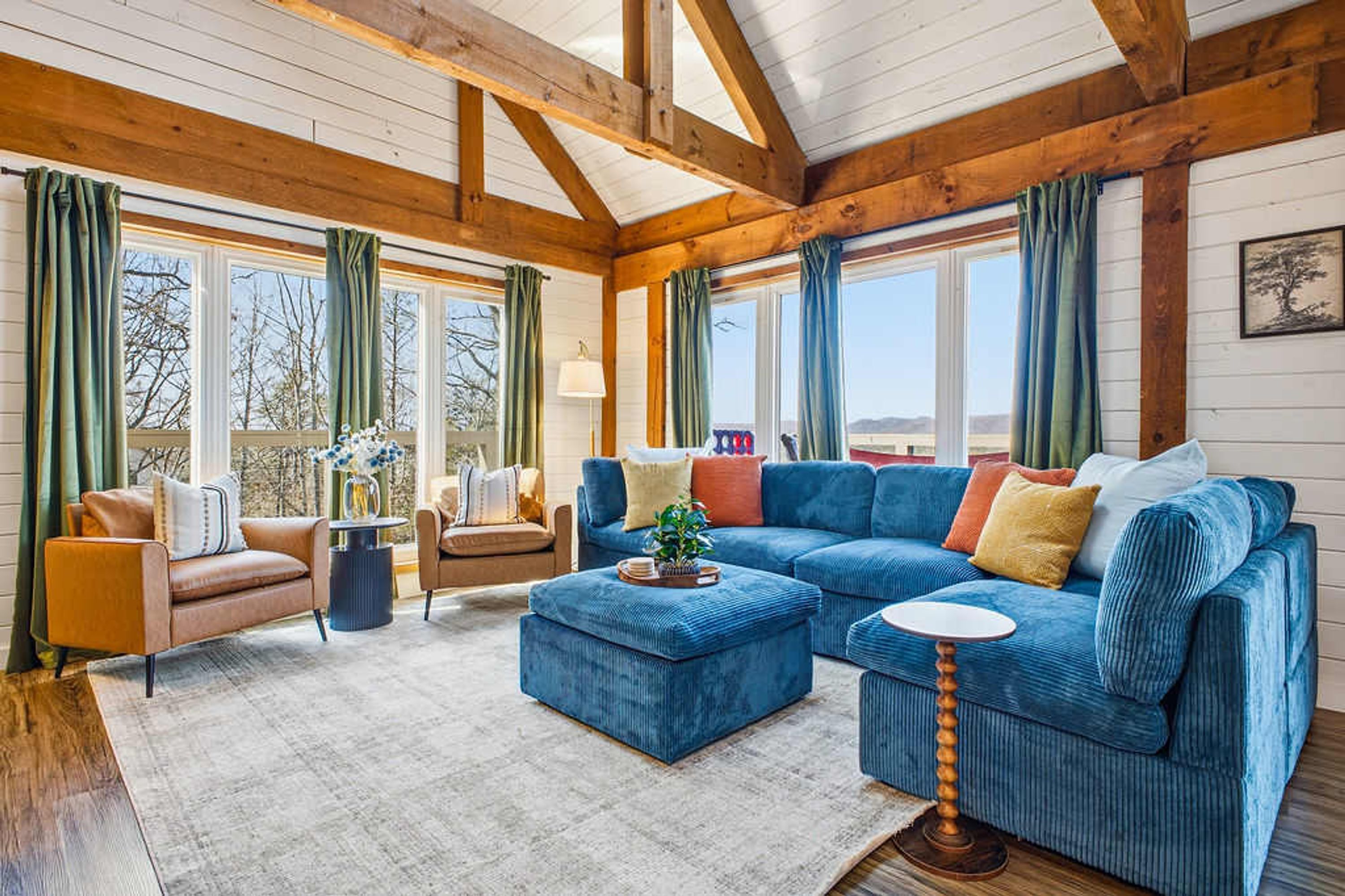 A spacious living room with a large blue sectional sofa, a coffee table, and a fireplace.