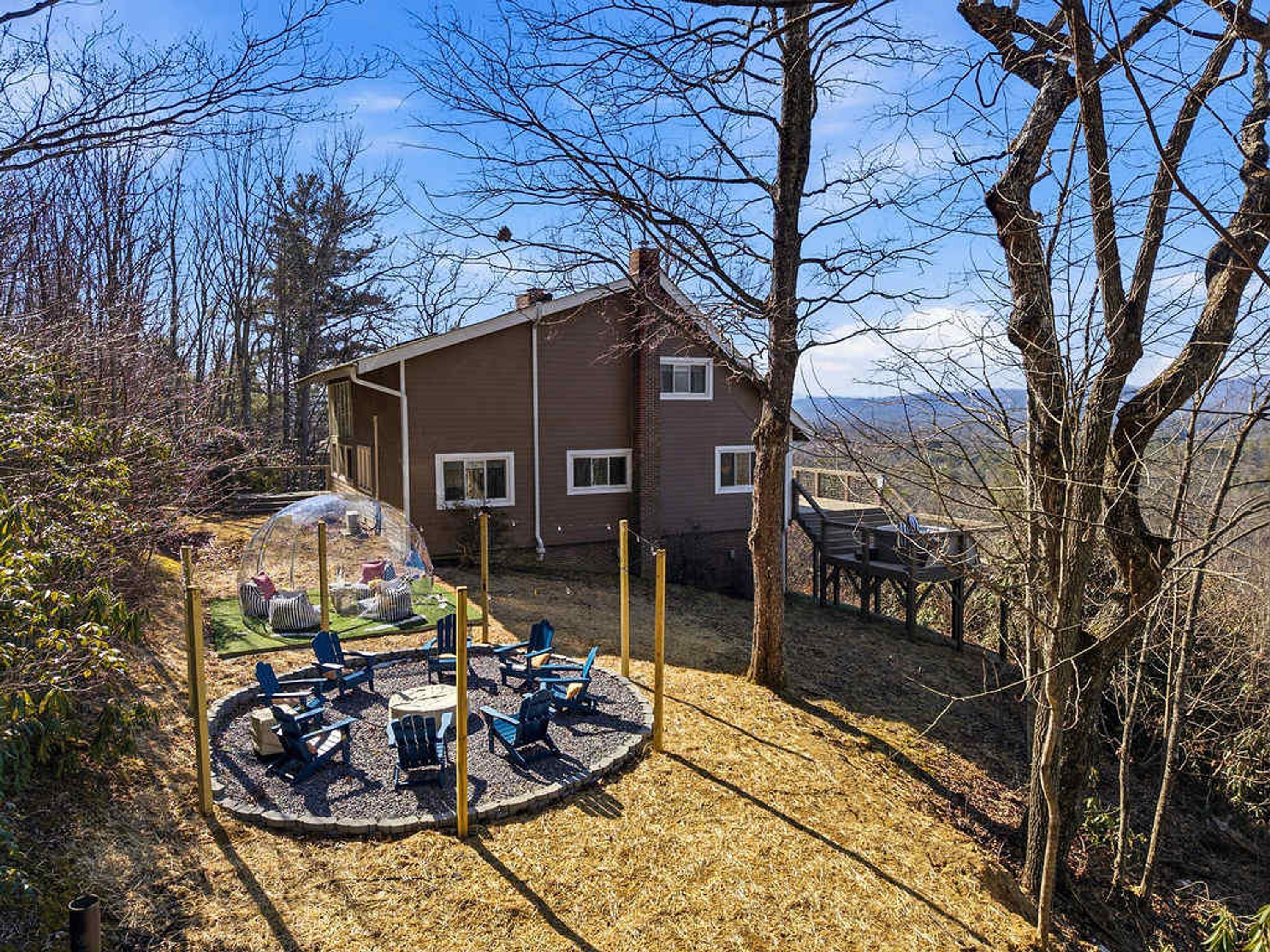 A house with a circular outdoor seating area and a view of the mountains.