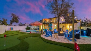 Una propiedad residencial con piscina, mobiliario exterior y césped bien cuidado.