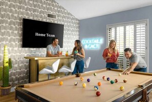 A pool table with billiard balls, a bar area with a neon sign, and a television screen displaying 'Home Team'. - Epic Family Getaway Sport Court Heated Pool (Scottsdale)