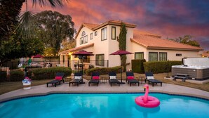 A pool area with lounge chairs and a hot tub, surrounded by a building with a tiled roof. - Epic Family Getaway Sport Court Heated Pool (Scottsdale)