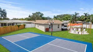 A residential property with a tennis court, a swimming pool, and outdoor seating. - Basketball Pickleball Pool Movie Game Room (Largo)