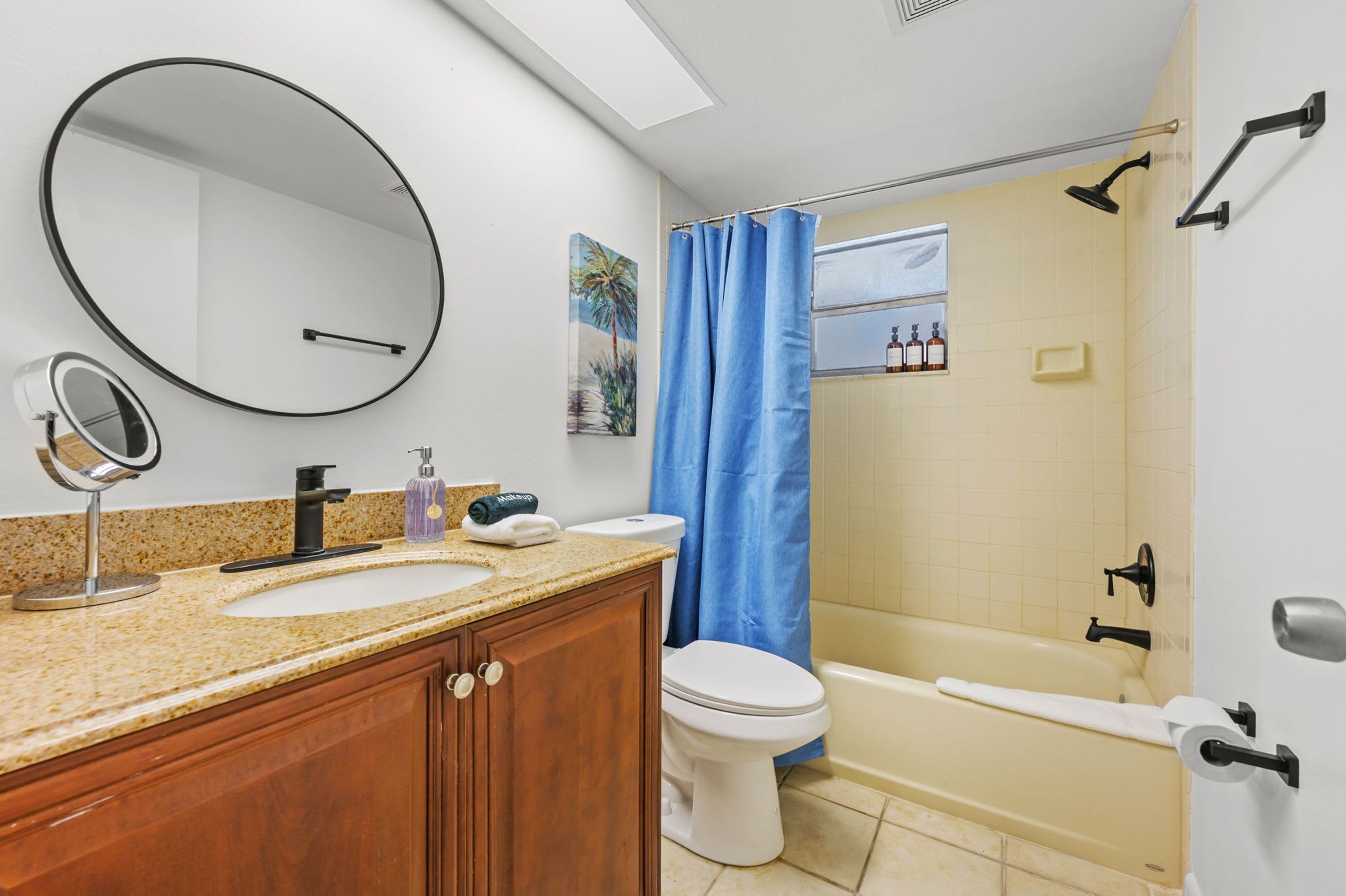 Ein Badezimmer mit Waschbecken, Spiegel, Toilette und Badewanne.
