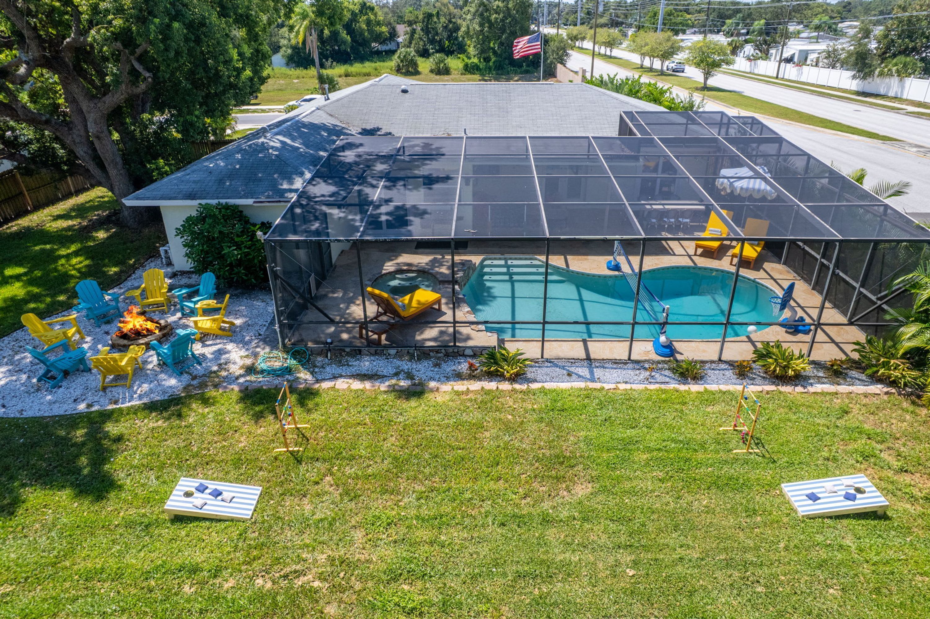 Una casa con piscina cubierta al aire libre, rodeada de sillas de jardín y una chimenea.