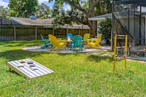 A backyard with a wooden deck, a fire pit, and outdoor furniture. - Pool Games More Fun for Everyone (Palm Harbor)