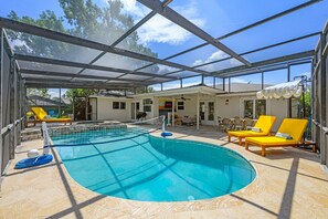 An indoor swimming pool with a glass ceiling, yellow lounge chairs, and a Netflix sign. - Pool Games More Fun for Everyone (Palm Harbor)