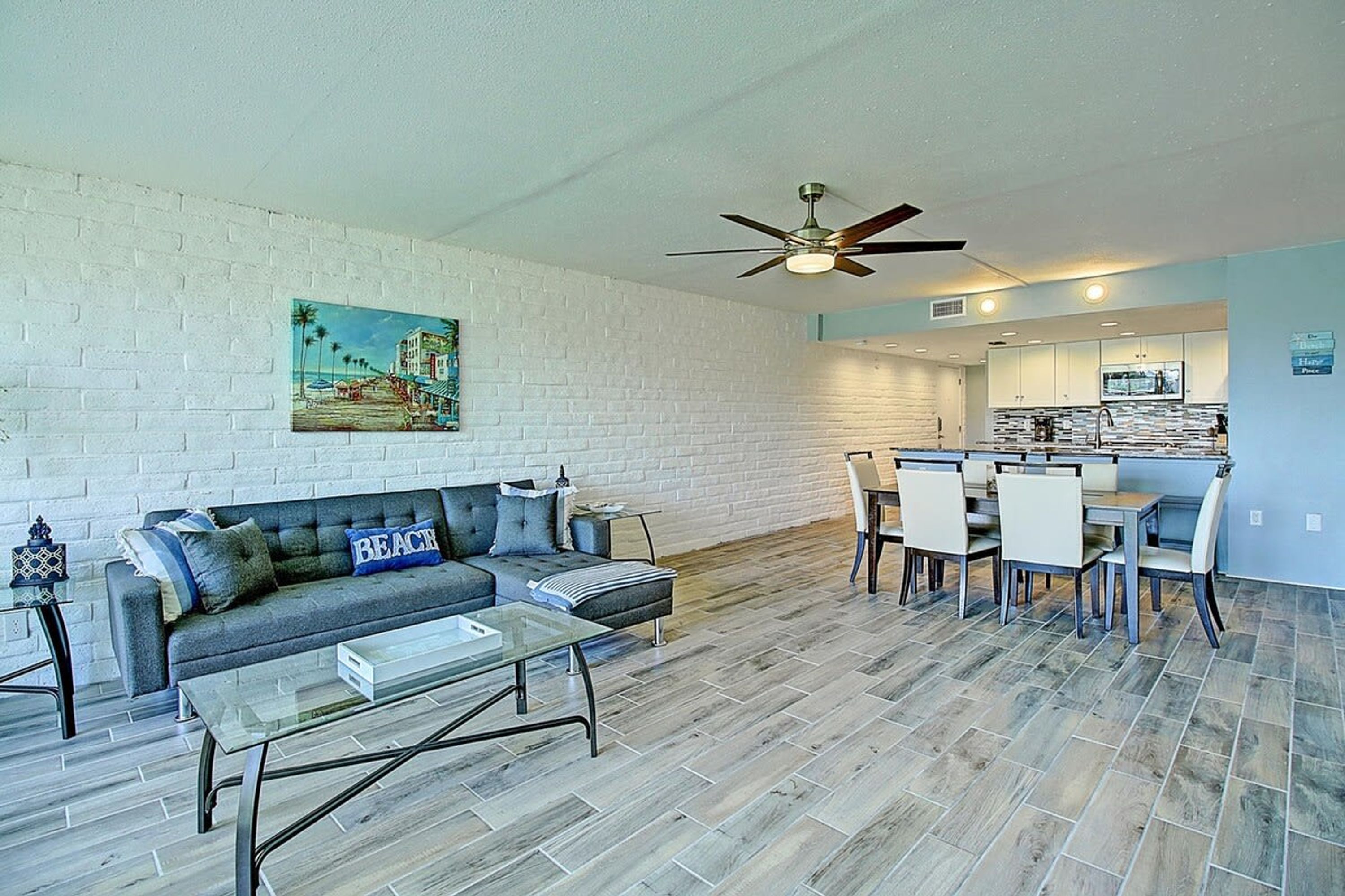 A living room with a sofa, coffee table, and a painting on the wall.
