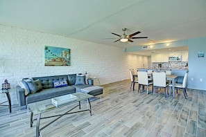 A living room with a sofa, coffee table, and a painting on the wall. - A Salty Day Getaway Beach Boardwalk Large Pool (Port Aransas)