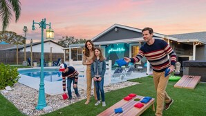 Ein Garten mit Pool, einer Holzterrasse und einem Neon-Schild.