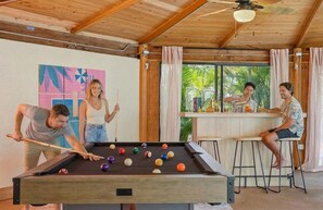 A pool table with balls, a bar area, and a room with wooden ceilings and windows. - Sleeps 14 Heated Pool Spa Arcade Putt Putt (Largo)