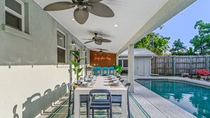 An outdoor dining area with a pool, ceiling fans, and a neon sign. - Sleeps 20 Basketball Court Pool Movie Room (Bradenton)
