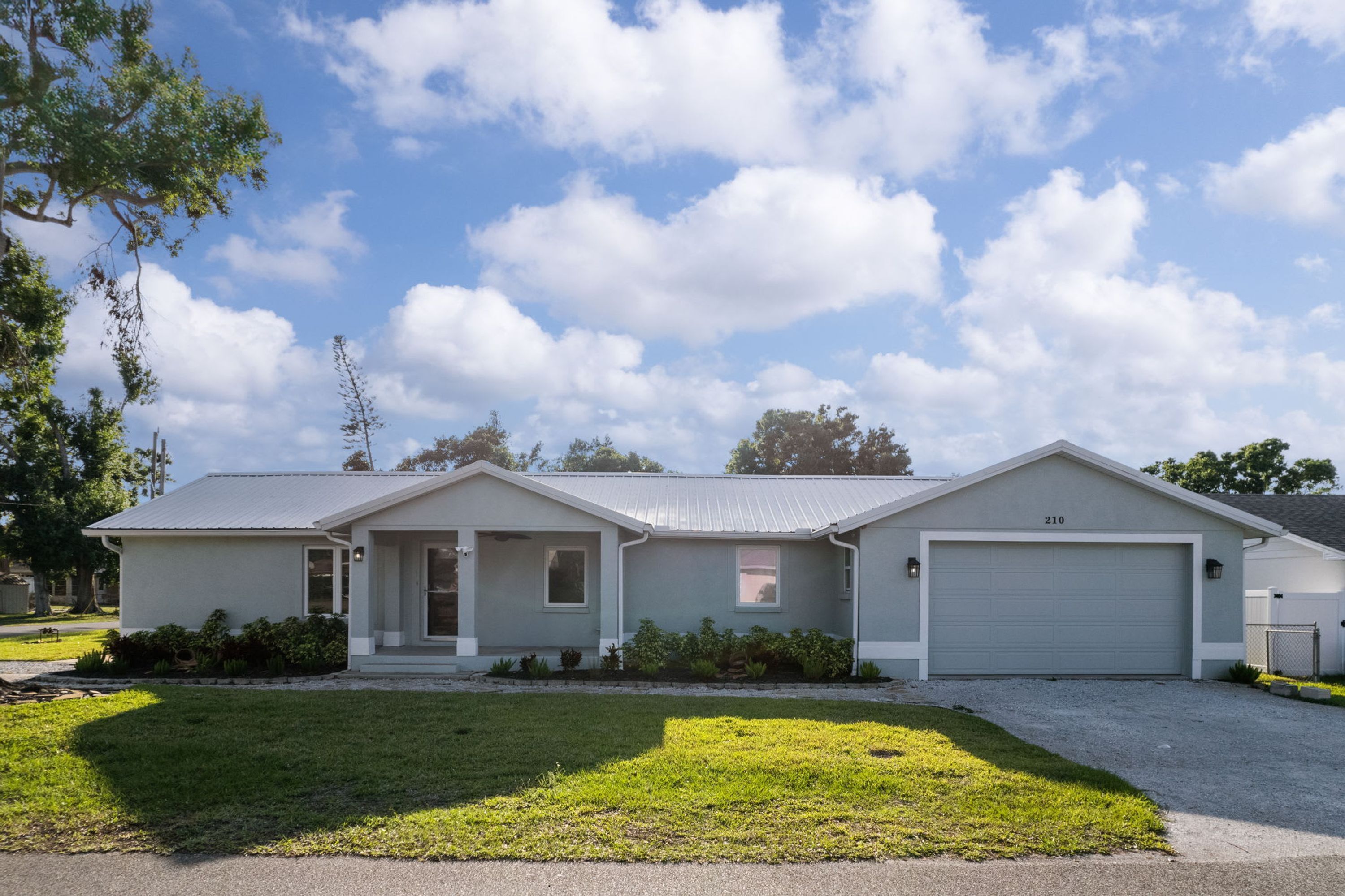A single-story house with a garage, a front porch, and a well-maintained lawn.