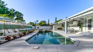A swimming pool with a sunshade, lounge chairs, and a covered patio area. - Sleeps 20 Basketball Court Pool Movie Room (Bradenton)