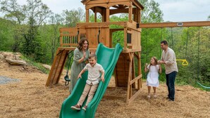 A wooden play structure with a slide, surrounded by a natural landscape. - Sleeps 20 Hot Tub Outdoor Theater Fire Pit Games (Fairview)