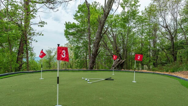 A miniature golf course with numbered holes and a putting green. - Sleeps 20 Hot Tub Outdoor Theater Fire Pit Games (Fairview)