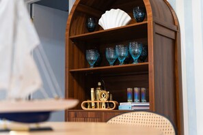 Un meuble en bois contenant de la verrerie et un objet décoratif.