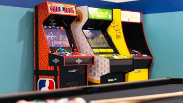 Three arcade machines with 'NBA JAM' and 'Golf' titles, a pool table, and a 'Paddle Pros' machine.