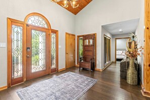 A hallway with wooden doors, a rug, and a bench. - Tampa Oasis Private Pool Sauna Sleeps 14 (Tampa)