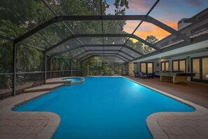 Piscina coberta com vista para árvores e um pôr do sol.