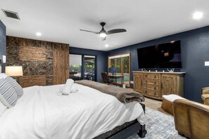 Ein Schlafzimmer mit einem Bett, einem Schreibtisch, einem Fernseher und einem Kleiderschrank.