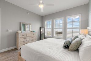 Une chambre à coucher avec un lit, une commode et un ventilateur de plafond.