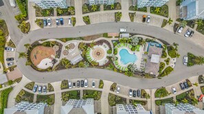 Ein Wohngebiet mit einer gewundenen Straße, mehreren Parkplätzen und einem zentralen, kreisförmigen Garten mit einem Brunnen.
