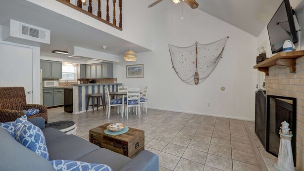 A spacious living area with a sofa, dining table, kitchen in the background, and a ceiling fan. - Canal Views Pool 2 Min to Beach Fishing Pier (Corpus Christi)