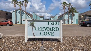 A sign for Leeward Cove with a clear sky and palm trees in the background. - Canal Views Pool 2 Min to Beach Fishing Pier (Corpus Christi)