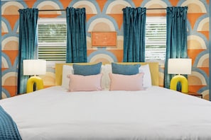 A hotel room with a bed, two bedside lamps, and a window with curtains. - Basketball Court Game Room Pool Hot Tub (Largo)