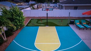A basketball court with a pool table adjacent to it. - Basketball Court Game Room Pool Hot Tub (Largo)