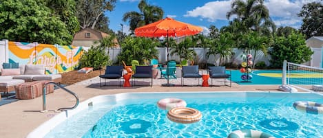 A swimming pool with lounge chairs and a colorful mural in the background.