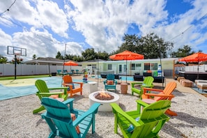 A poolside area with colorful Adirondack chairs, a fire pit, and a hot tub. - Basketball Court Game Room Pool Hot Tub (Largo)