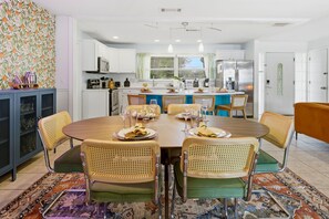 A dining area with a round table, four chairs, and a kitchen in the background. - Basketball Court Game Room Pool Hot Tub (Largo)